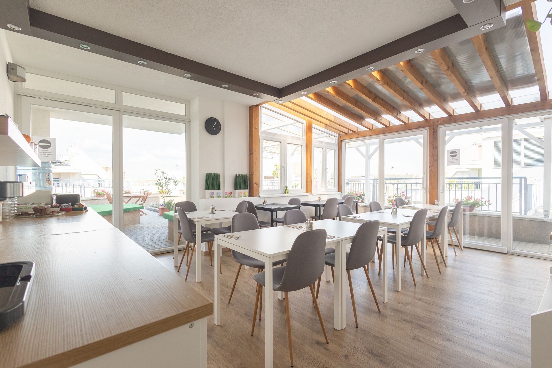 A large room with tables and chairs and a lot of windows.