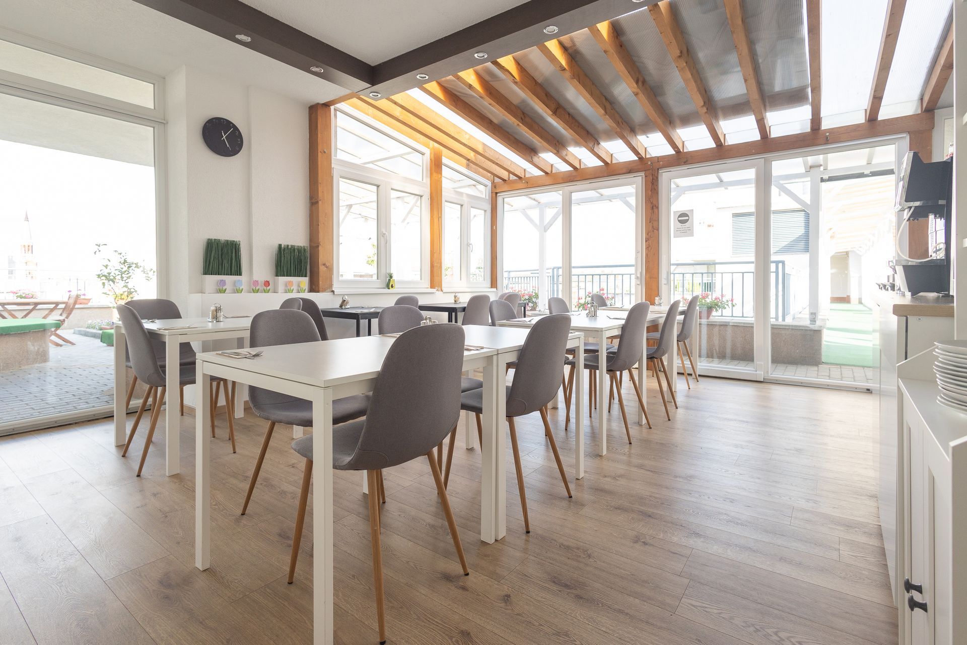 There are many tables and chairs in the room.