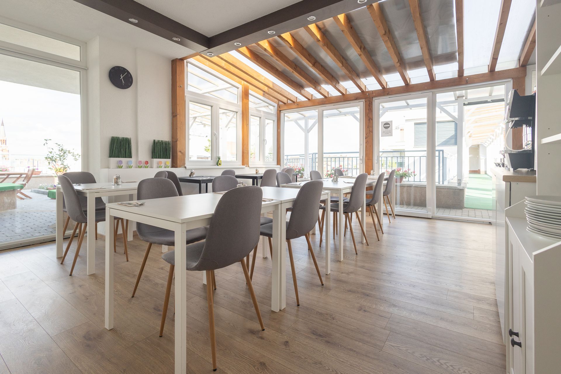 There are many tables and chairs in the room.