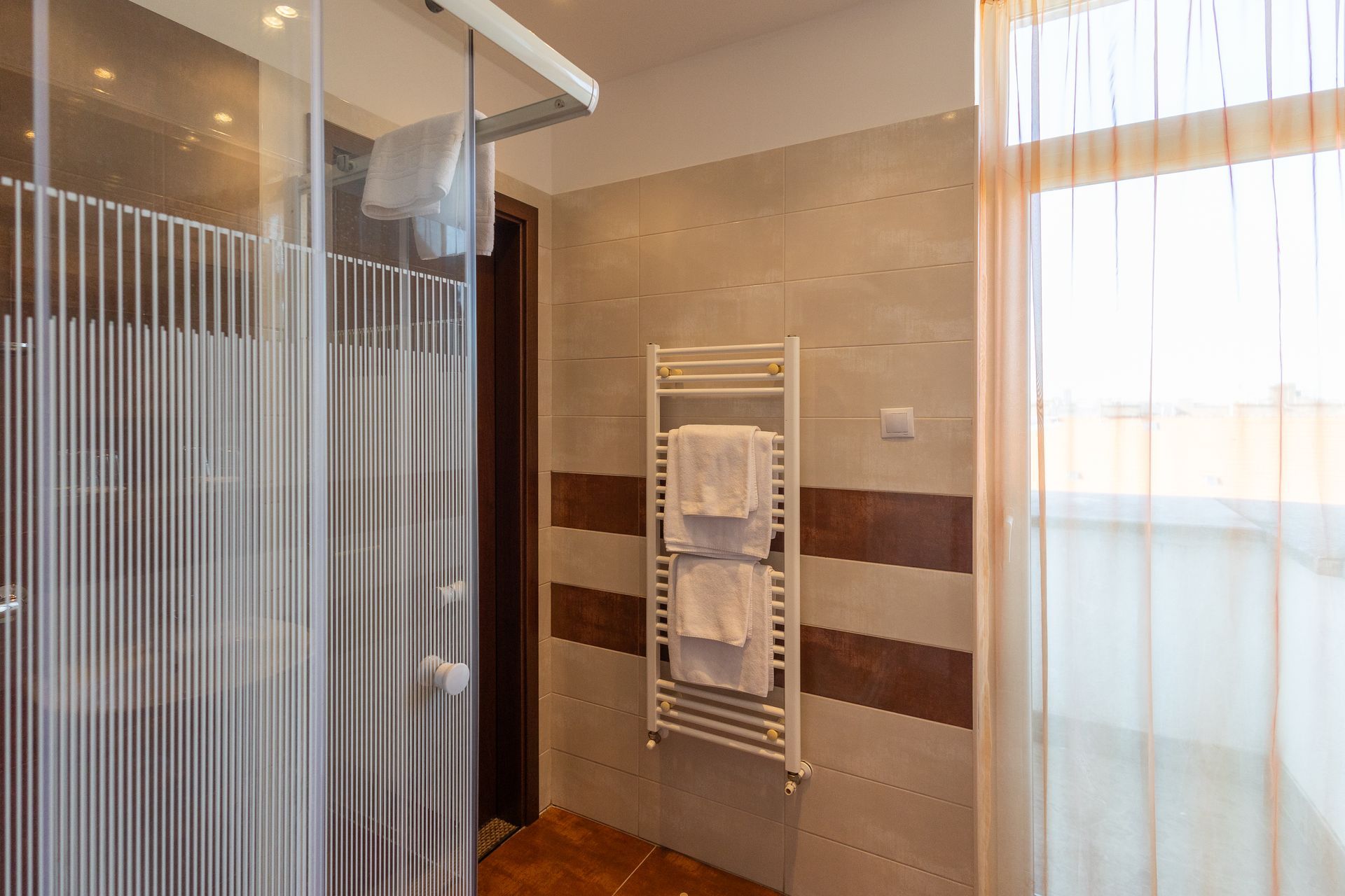 A bathroom with a towel rack and a shower stall.