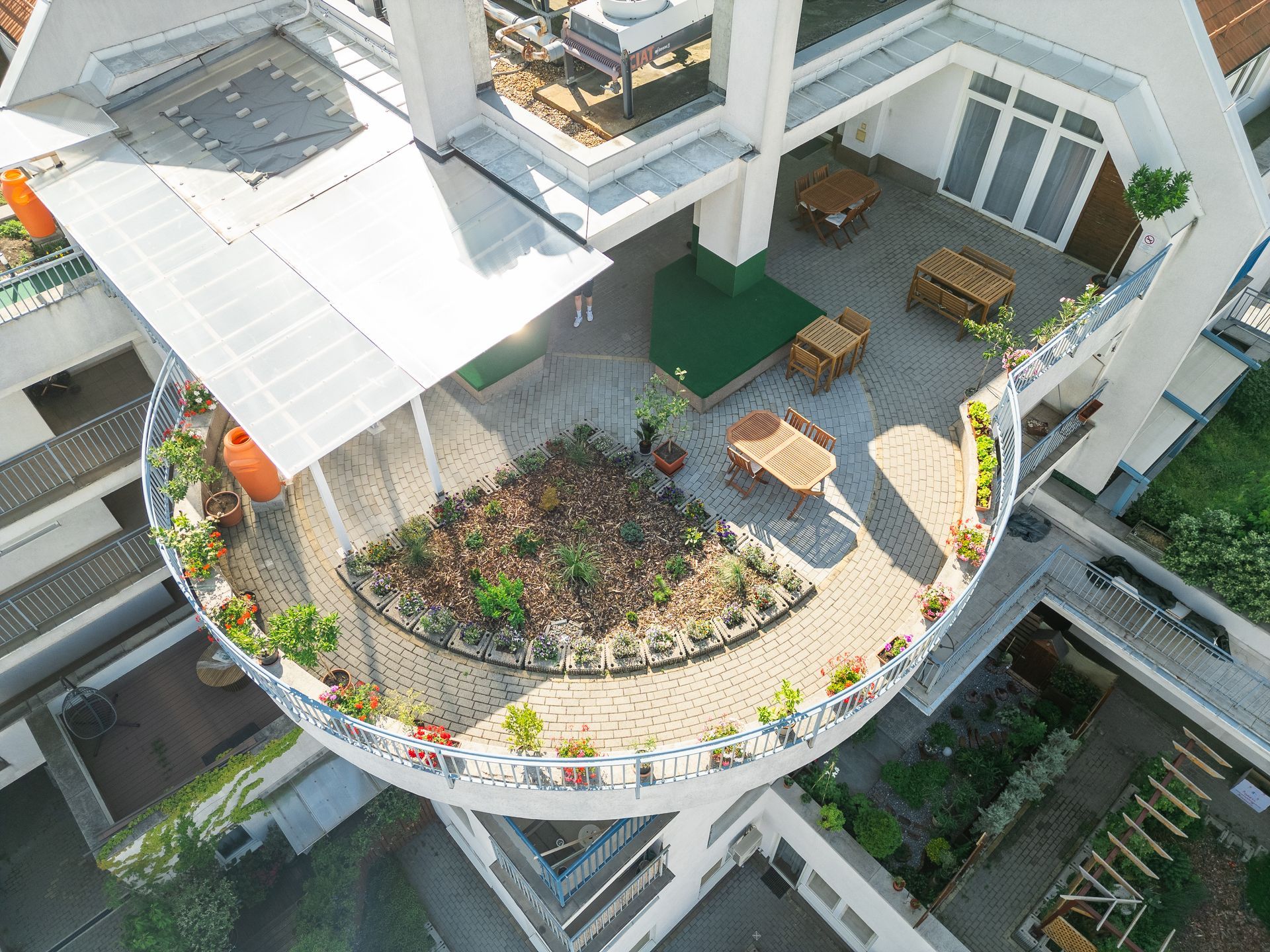 An aerial view of a rooftop garden with tables and chairs.