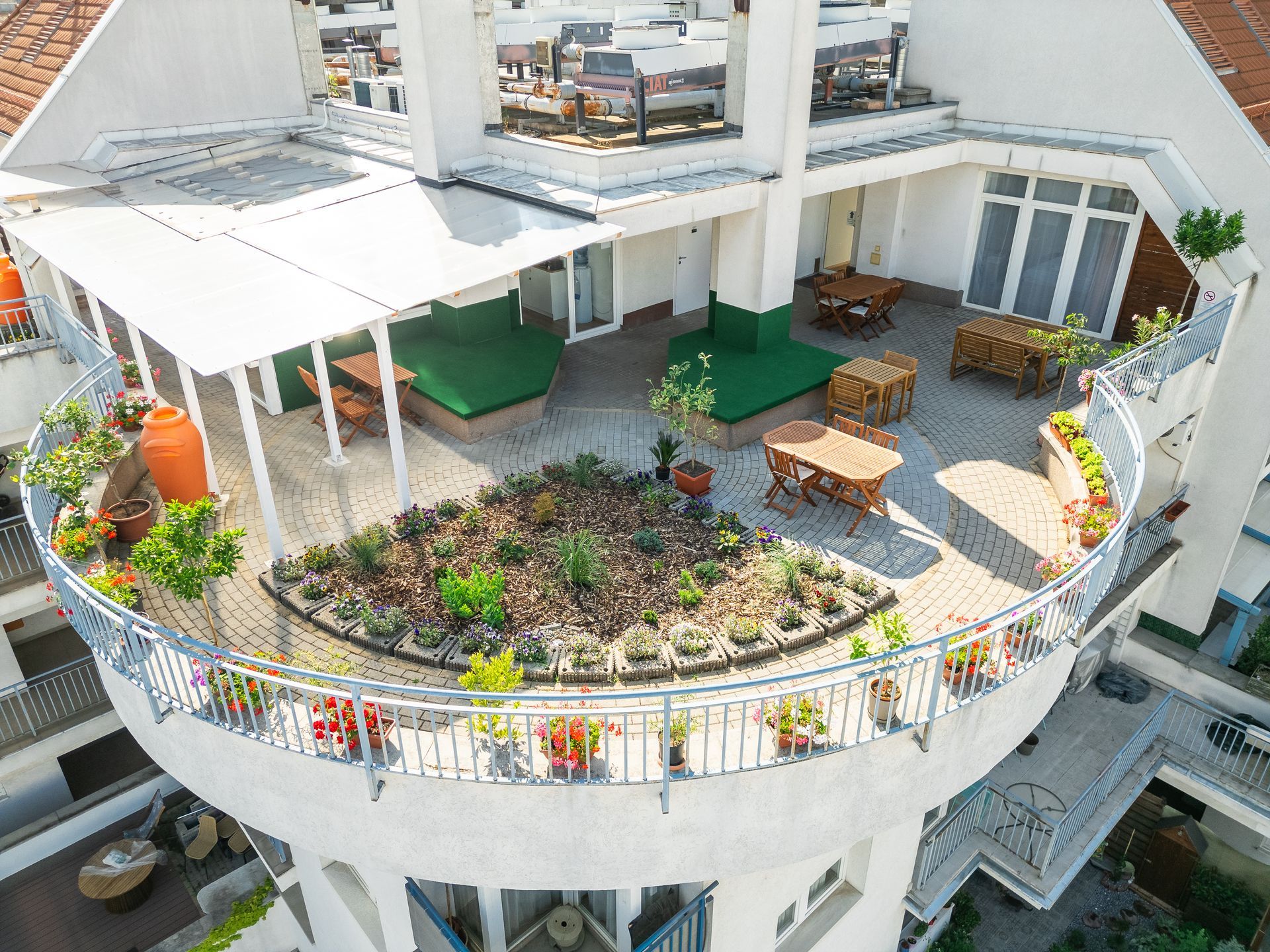 An aerial view of a balcony with a circular garden in the middle of it.