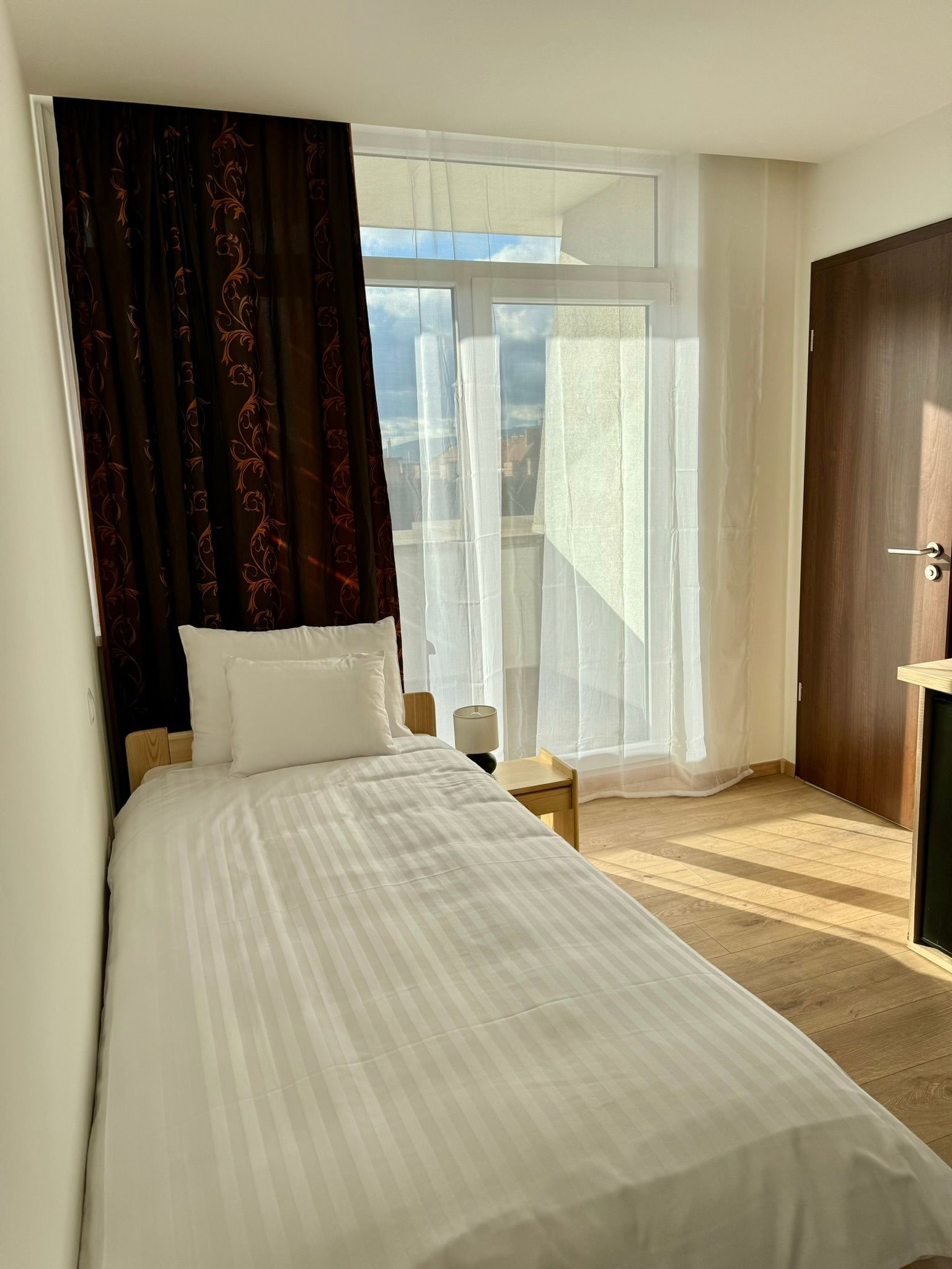 A bedroom with a single bed and a sliding glass door