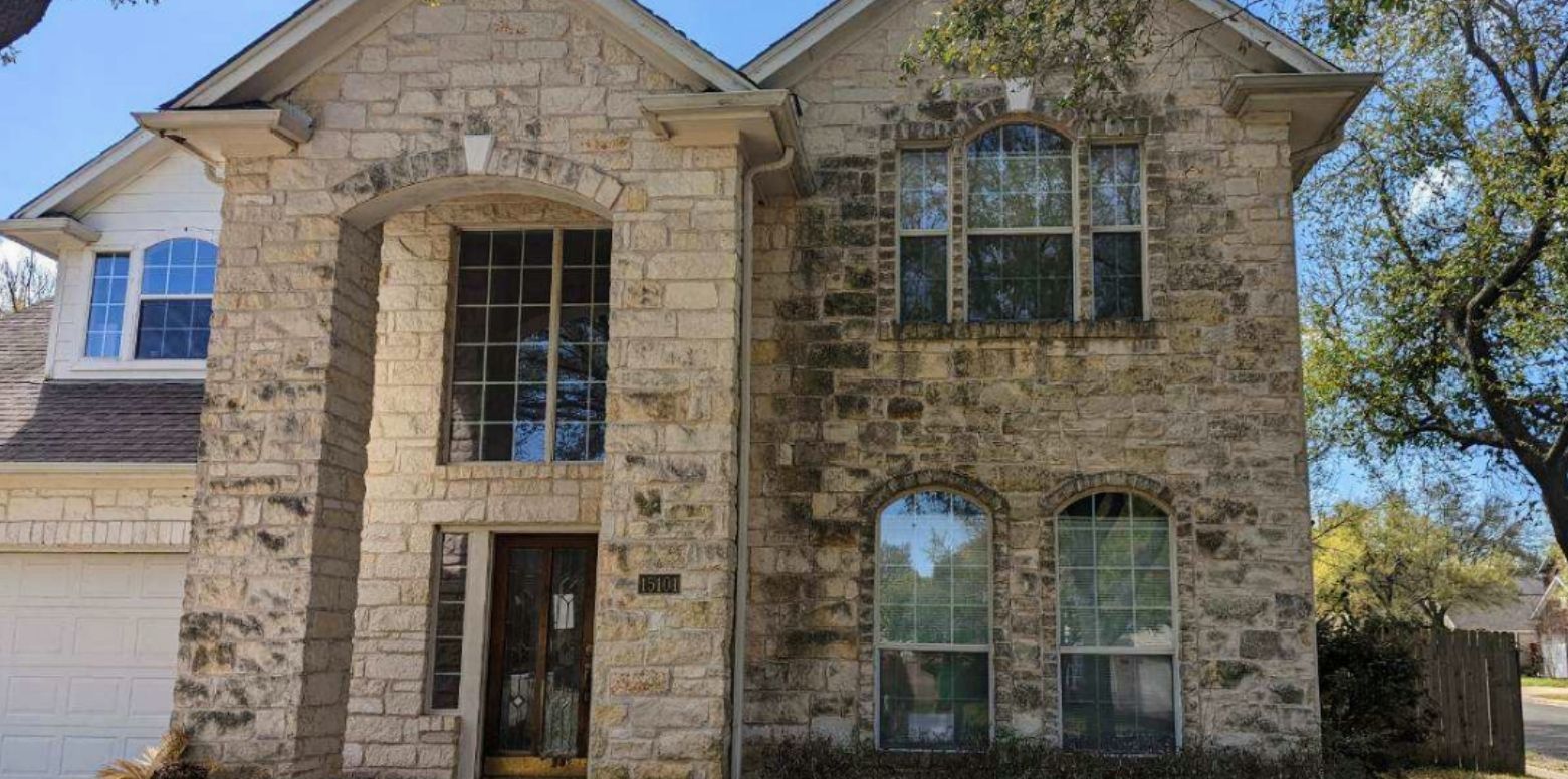 A large brick house with a lot of windows is for sale.