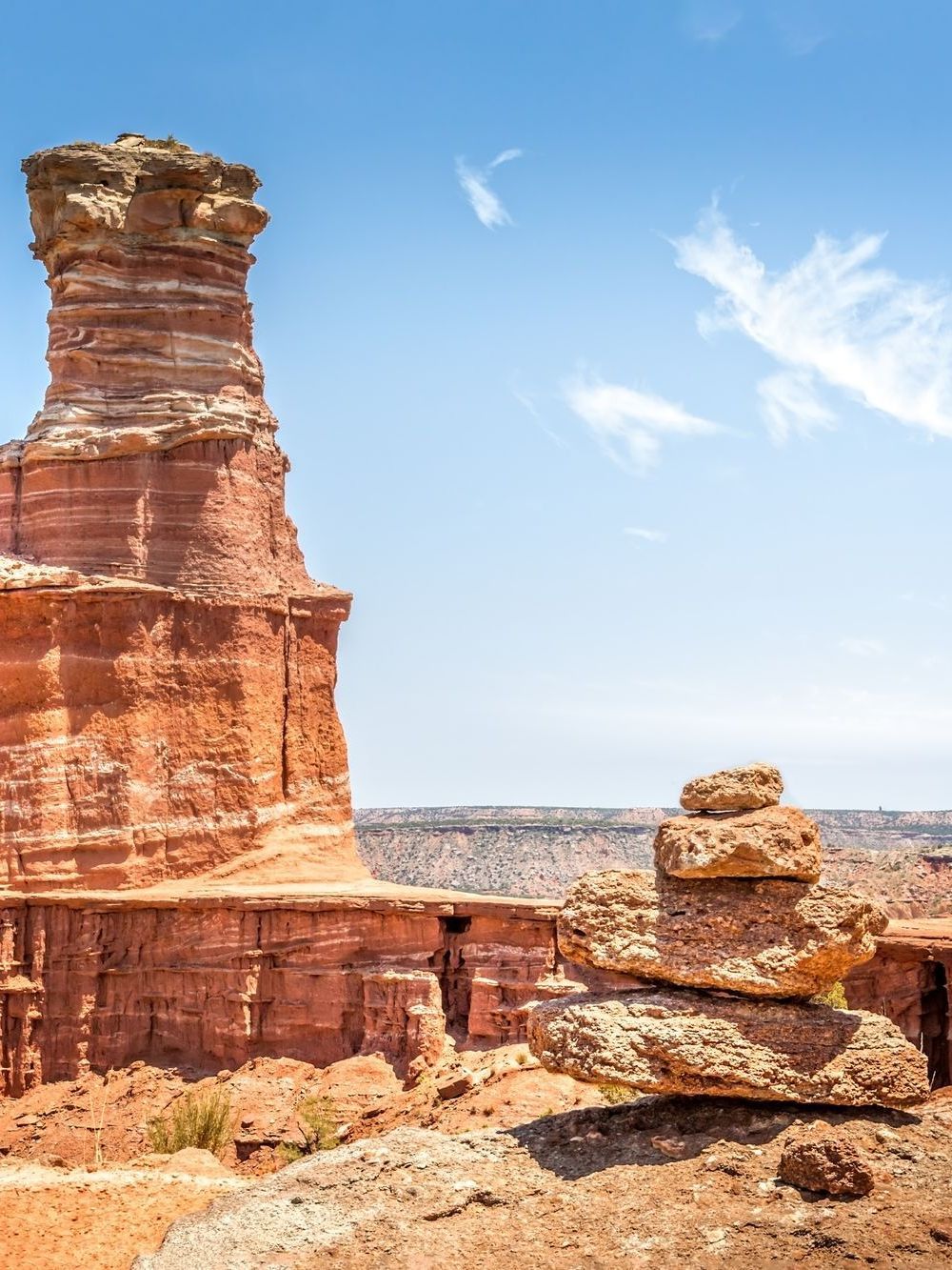 A wooden walkway leading to a gazebo overlooking a body of water at sunset.