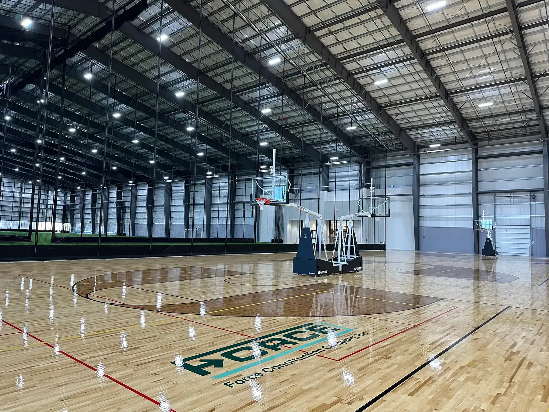 An image of a basketball court with the Force Construction logo painted on it.