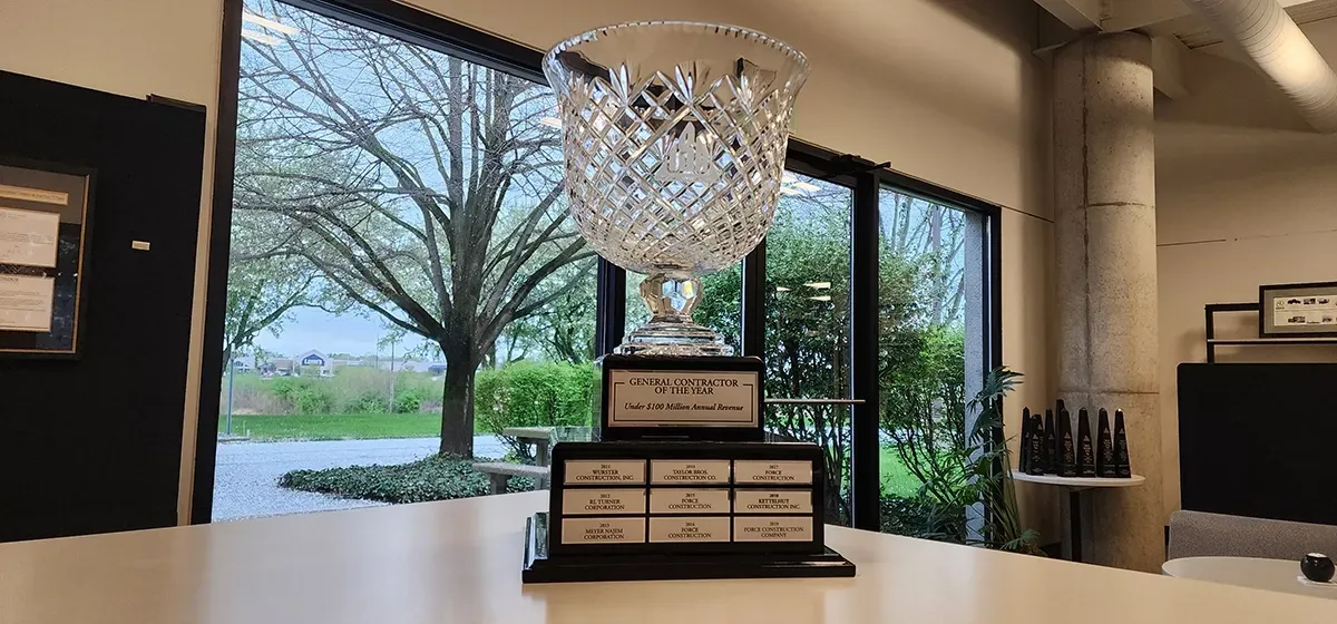 A trophy is sitting on a table in front of a window.