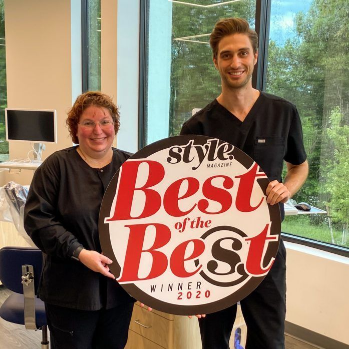 A man and a woman are holding a sign that says best of the best