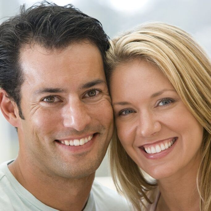 A man and a woman are smiling for the camera