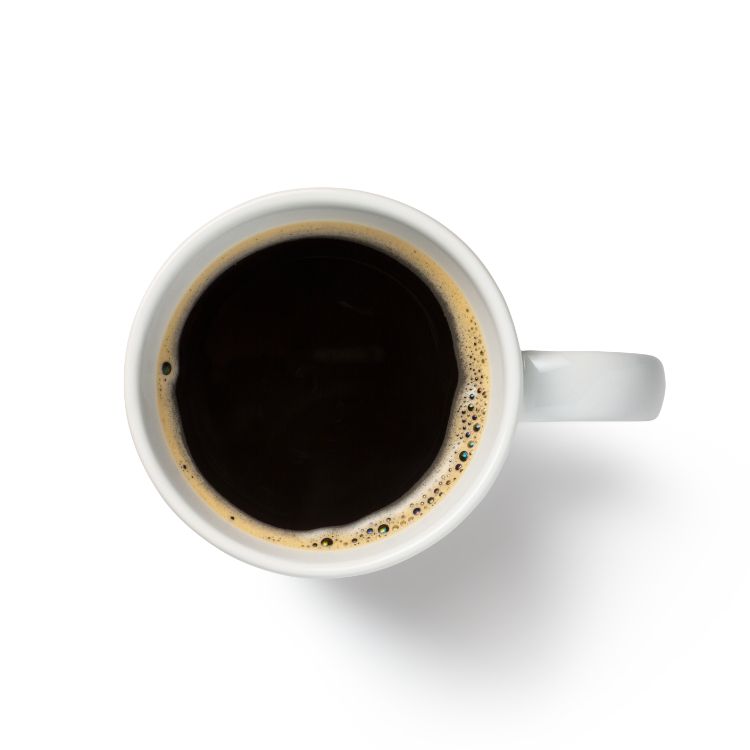 A cup of coffee is shown from above on a white background