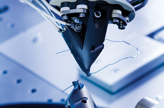 A close up of a robotic arm holding a wire