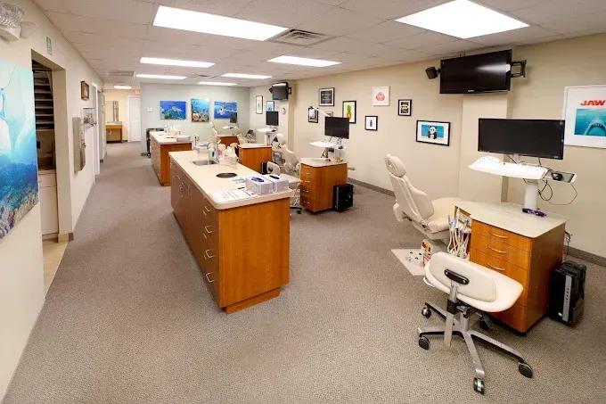 Dental office interior with patient chairs, treatment areas, and decorative art.