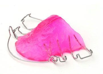 A close up of a pink dental retainer on a white background.