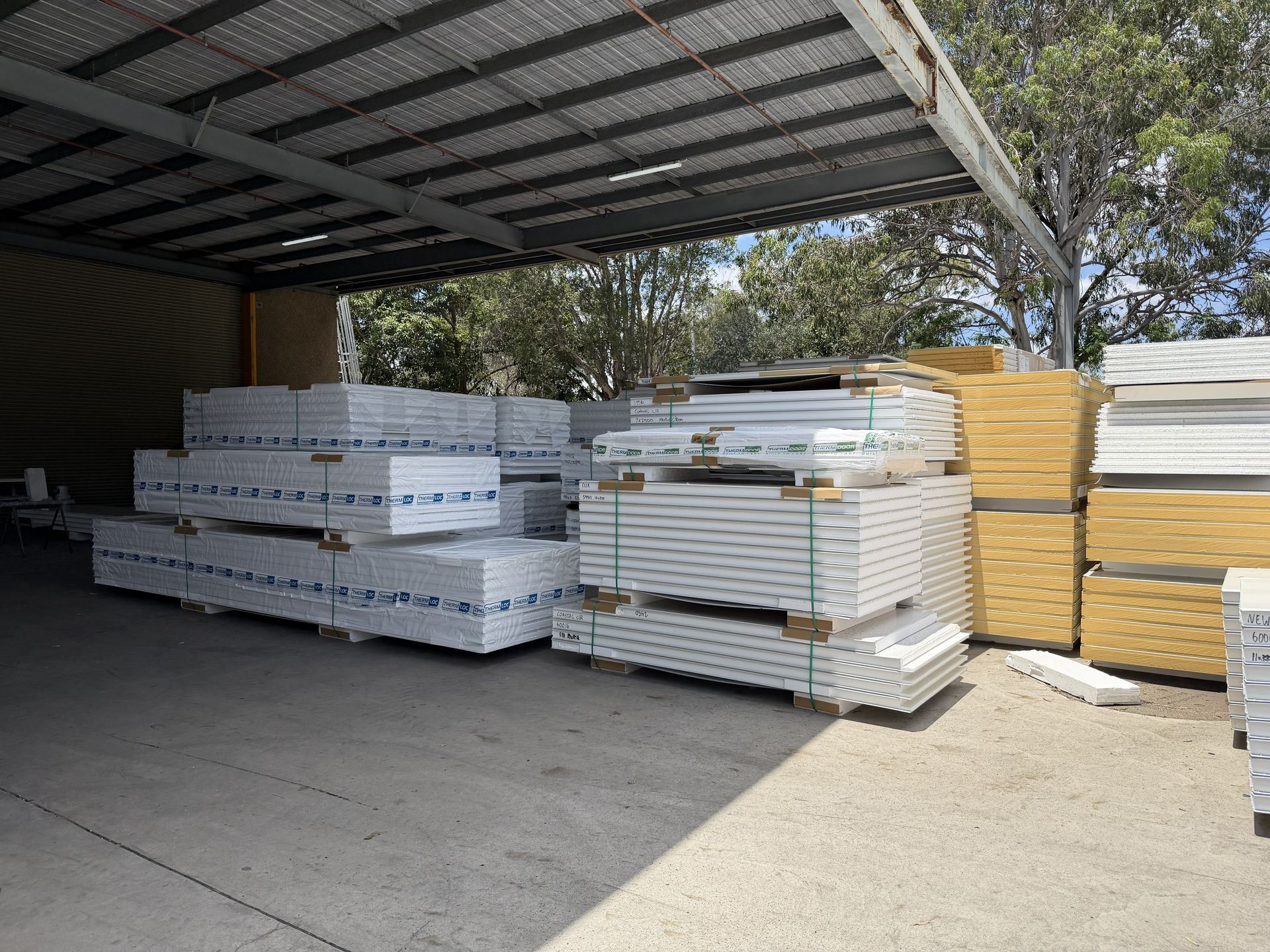Stacks of insulation panels inside a warehouse, creating a narrow aisle.