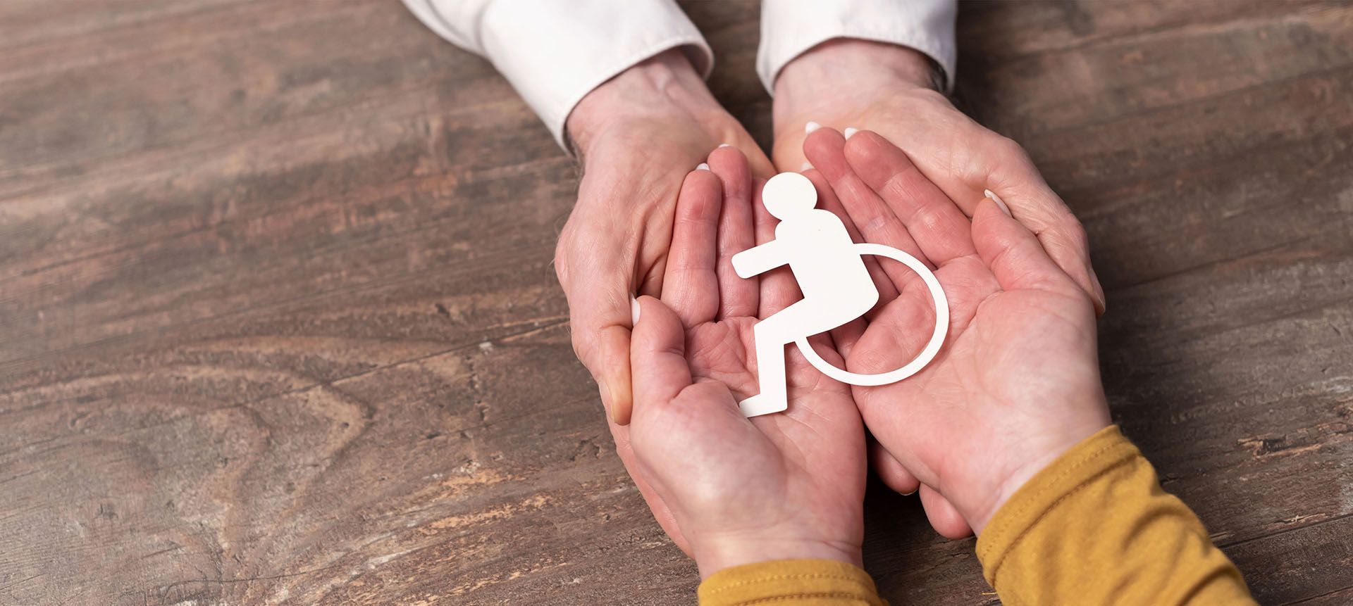 two people holding a cut out of a PWD symbol