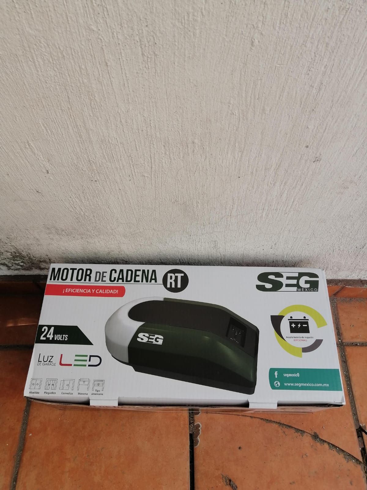 Abridor de puerta de garaje en caja, verde oscuro con detalles blancos, logotipo 