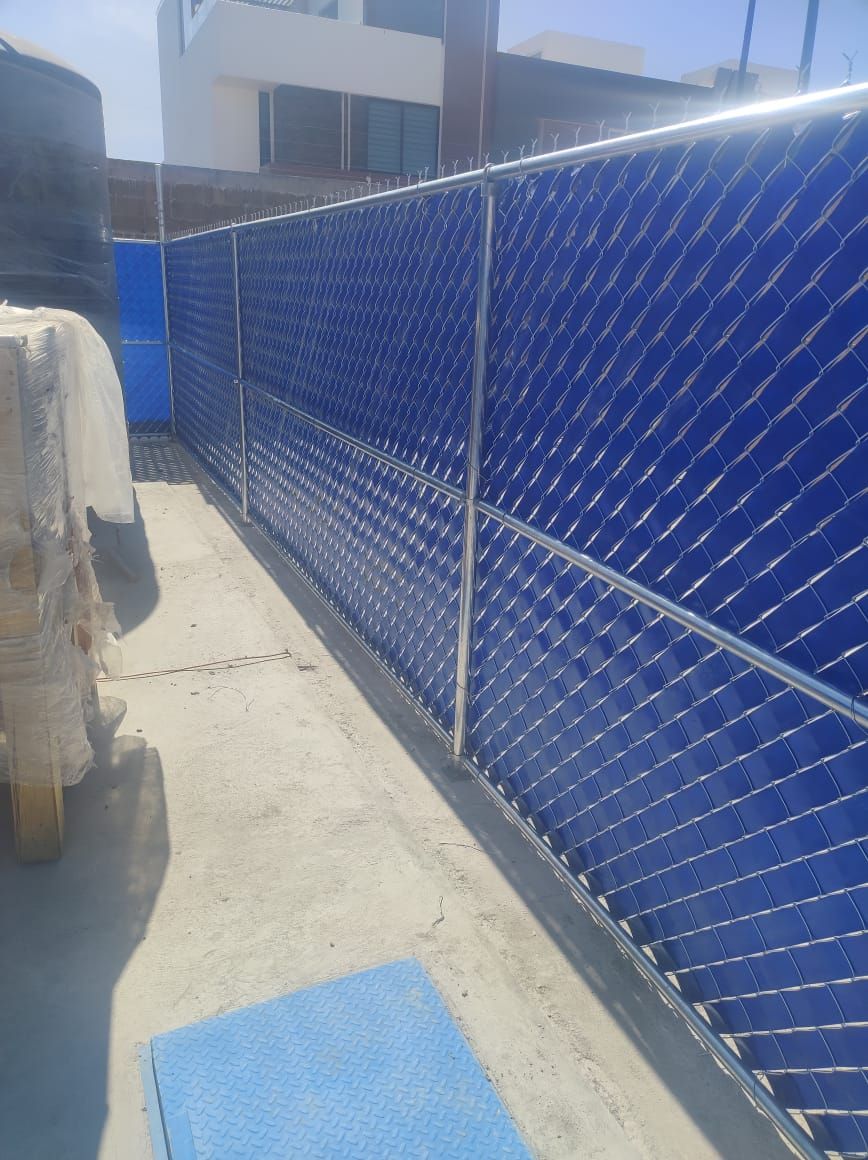 Calentadores solares de agua en un tejado, con paneles azules en una estructura metálica. Día soleado.