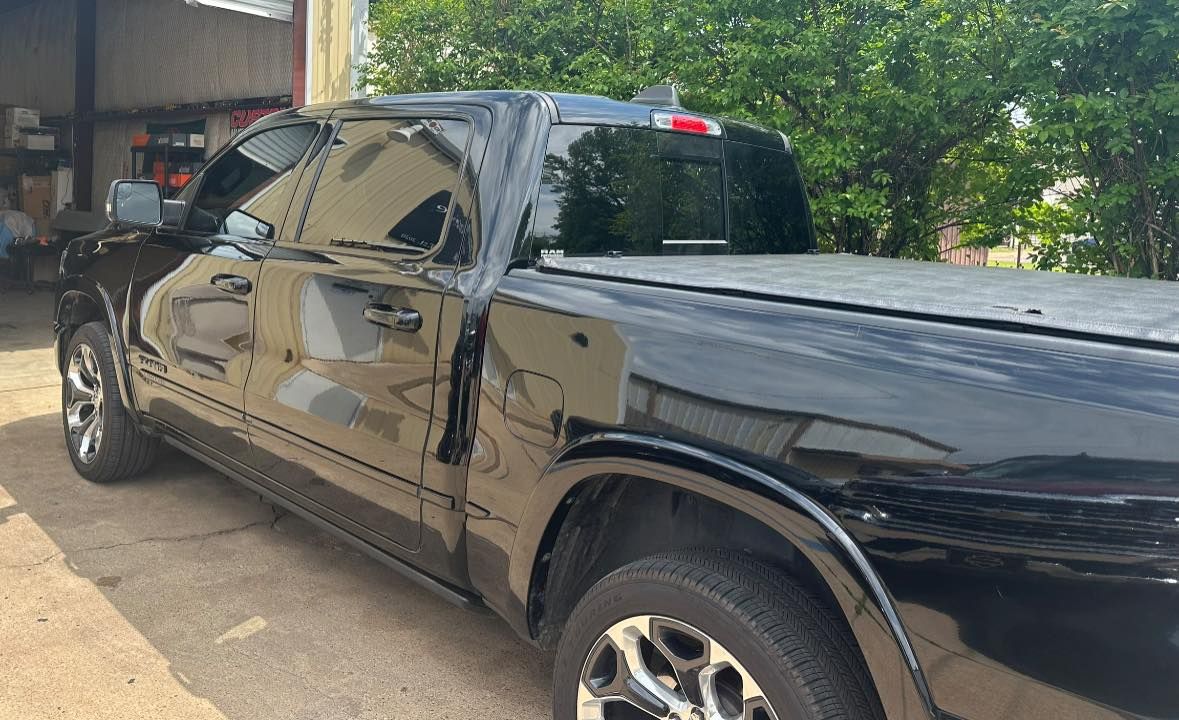 A black pickup truck is parked in a parking lot.