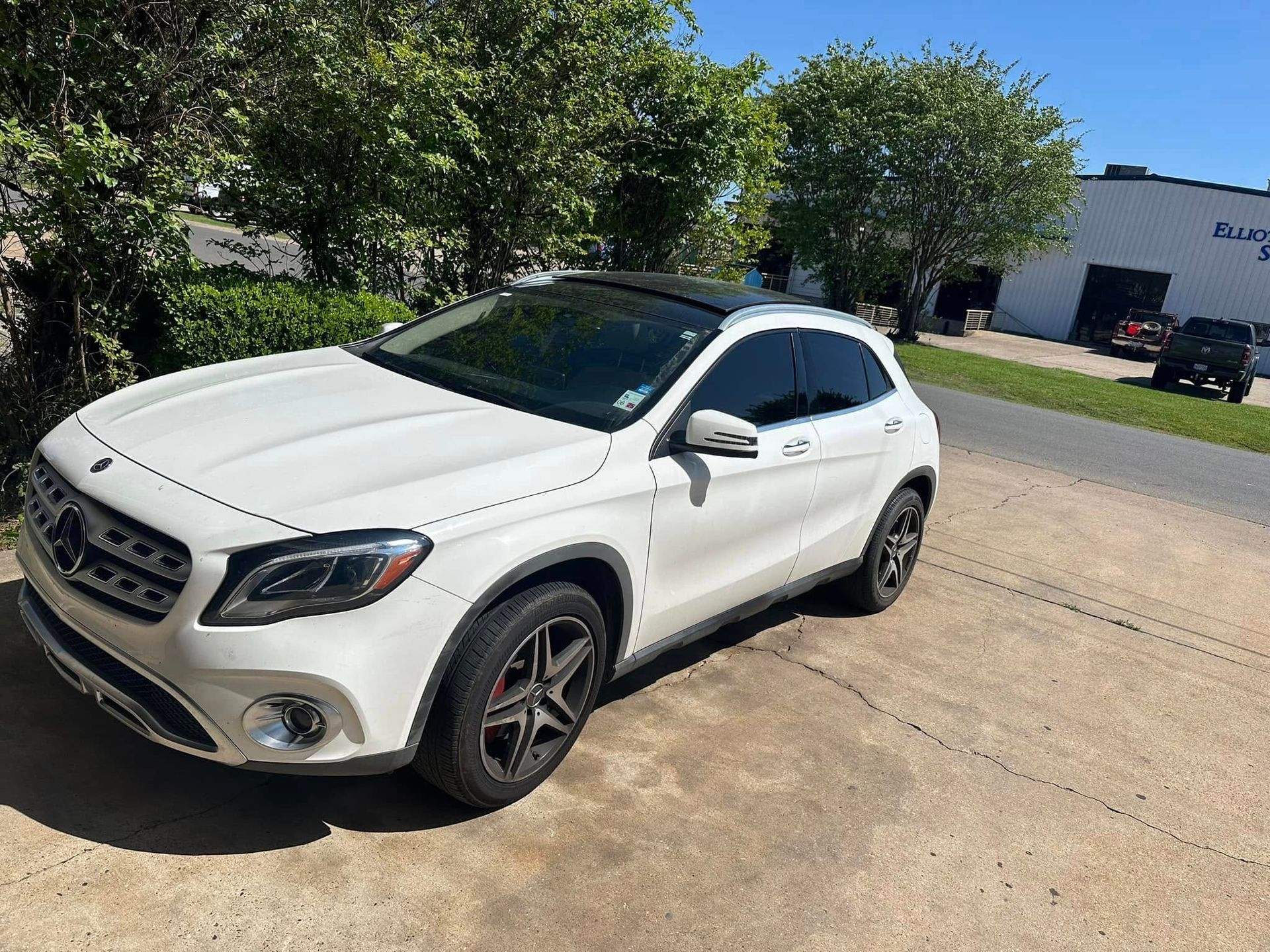 A white mercedes benz gla is parked on the side of the road.