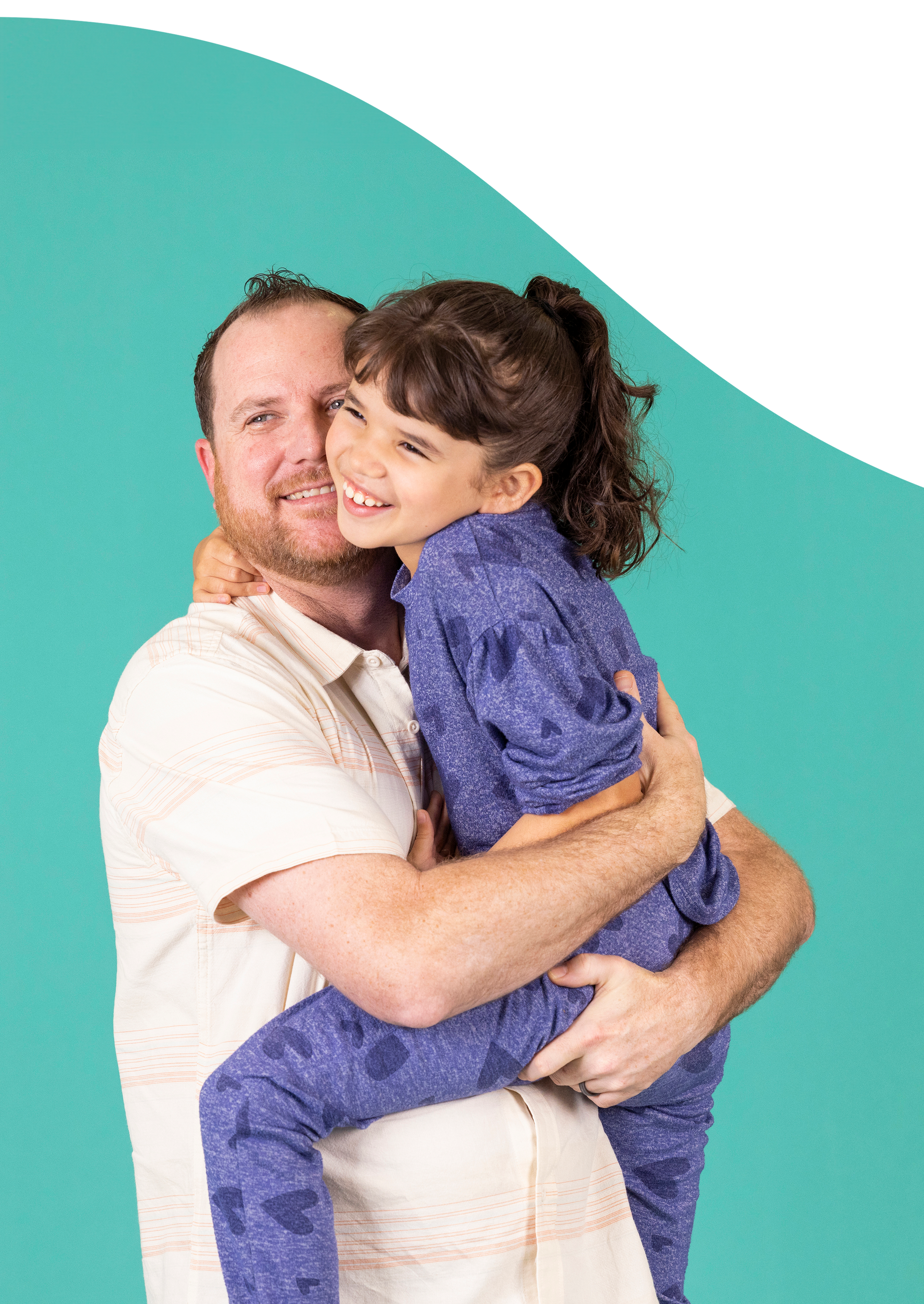 A man is holding a his daughter in his arms.