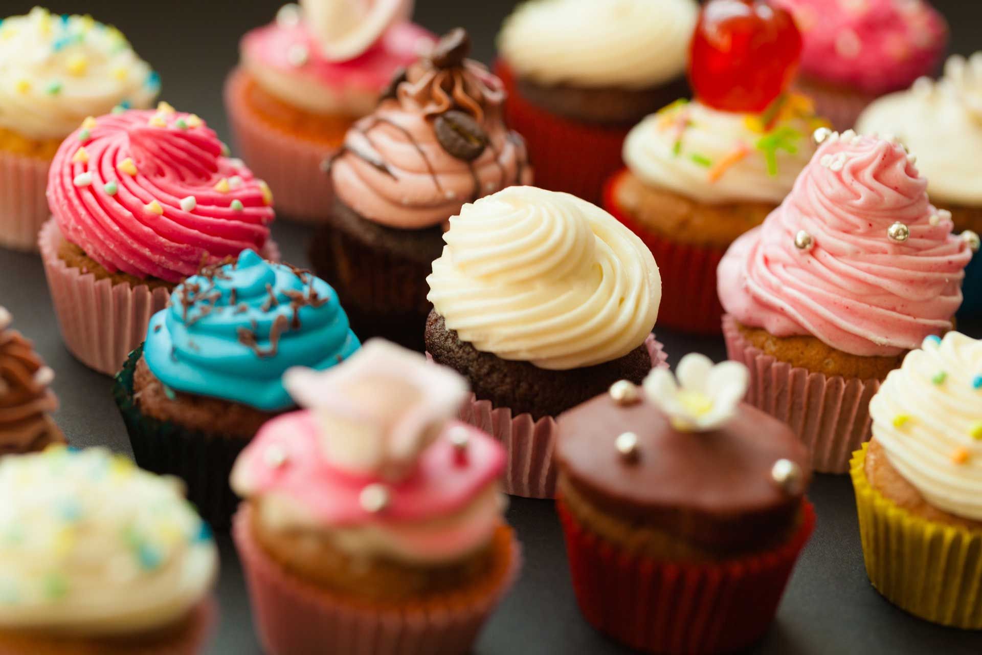 Close-up of assorted cupcakes with colorful frosting and decorations.