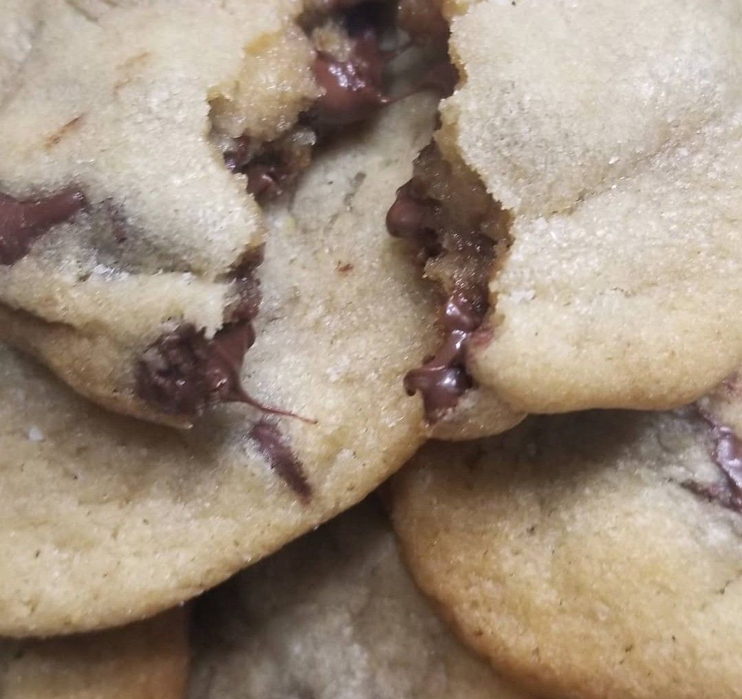 Chocolate chip cookies, one broken open revealing melted chocolate.