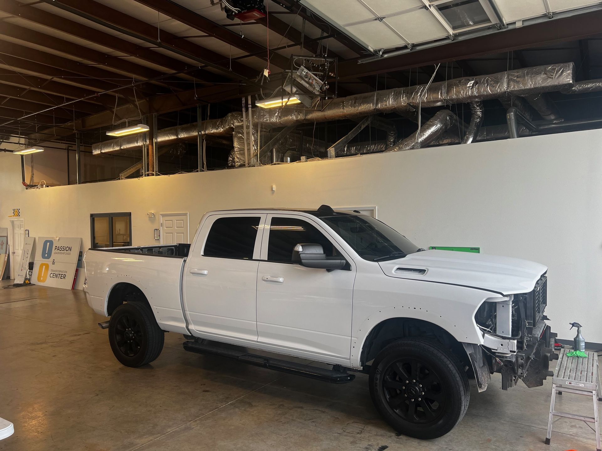 A white truck is parked in a garage.