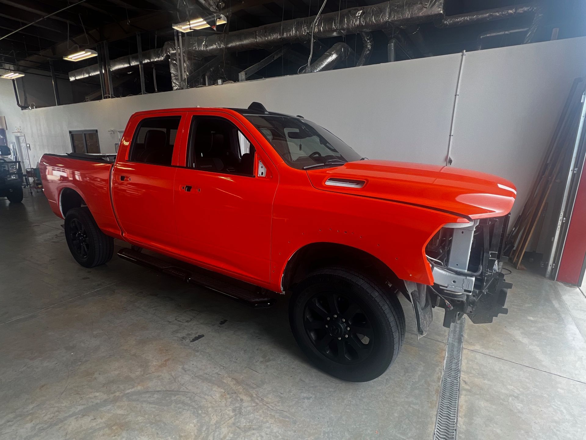A red dodge ram truck is parked in a garage.