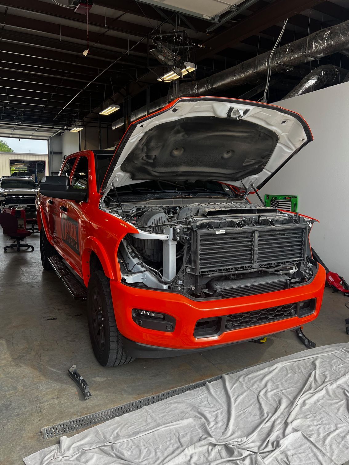 A red truck with the hood open is sitting in a garage.