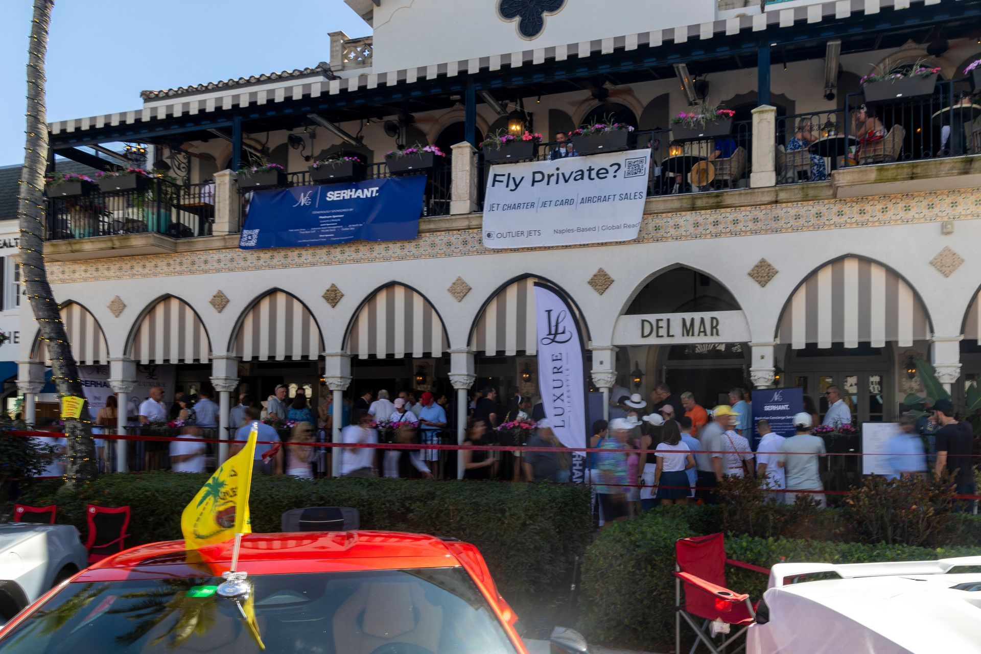 Crowd gathered outside the Del Mar building, banner