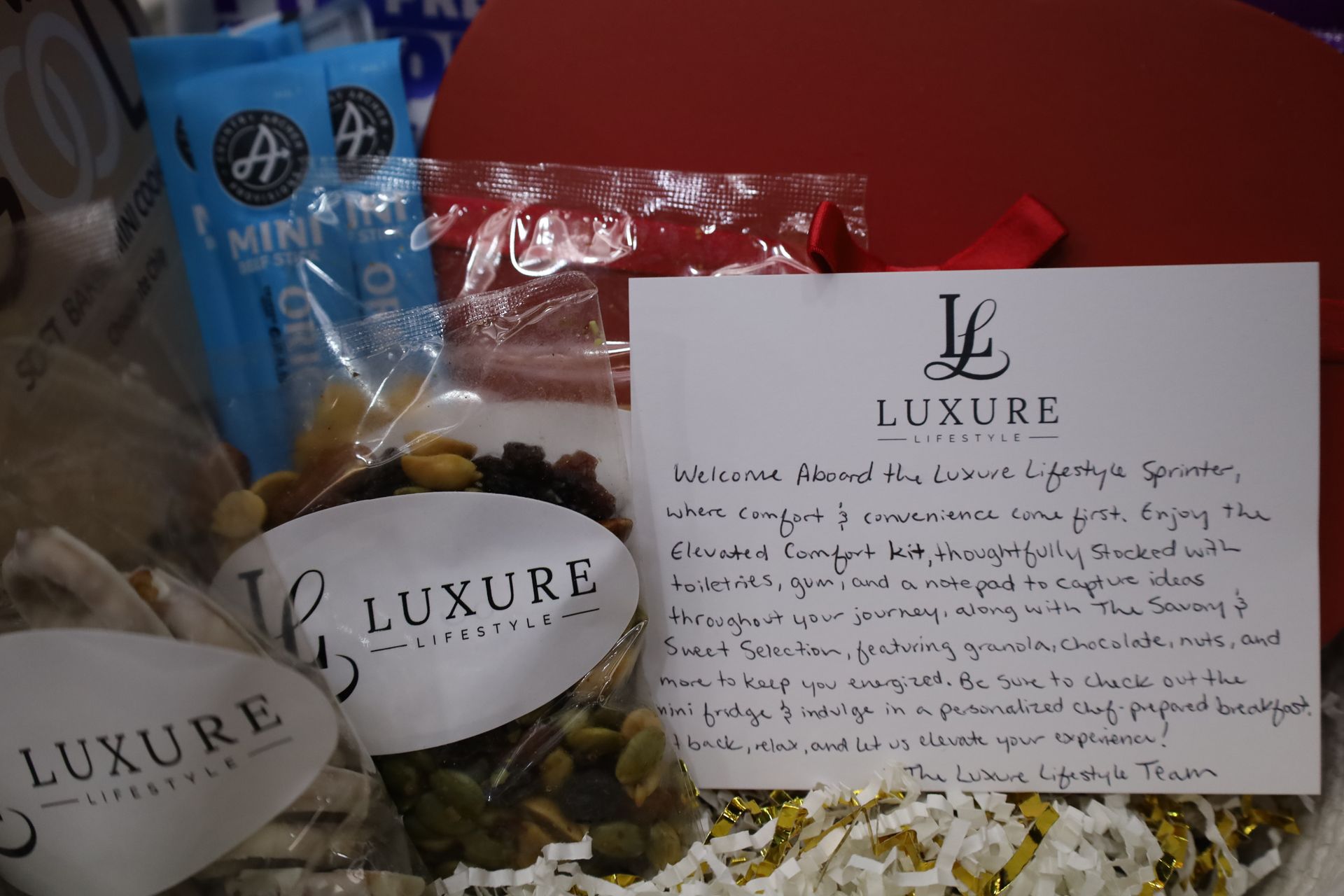 Gift basket with snacks, a welcome note, and Luxe Lifestyle branding.