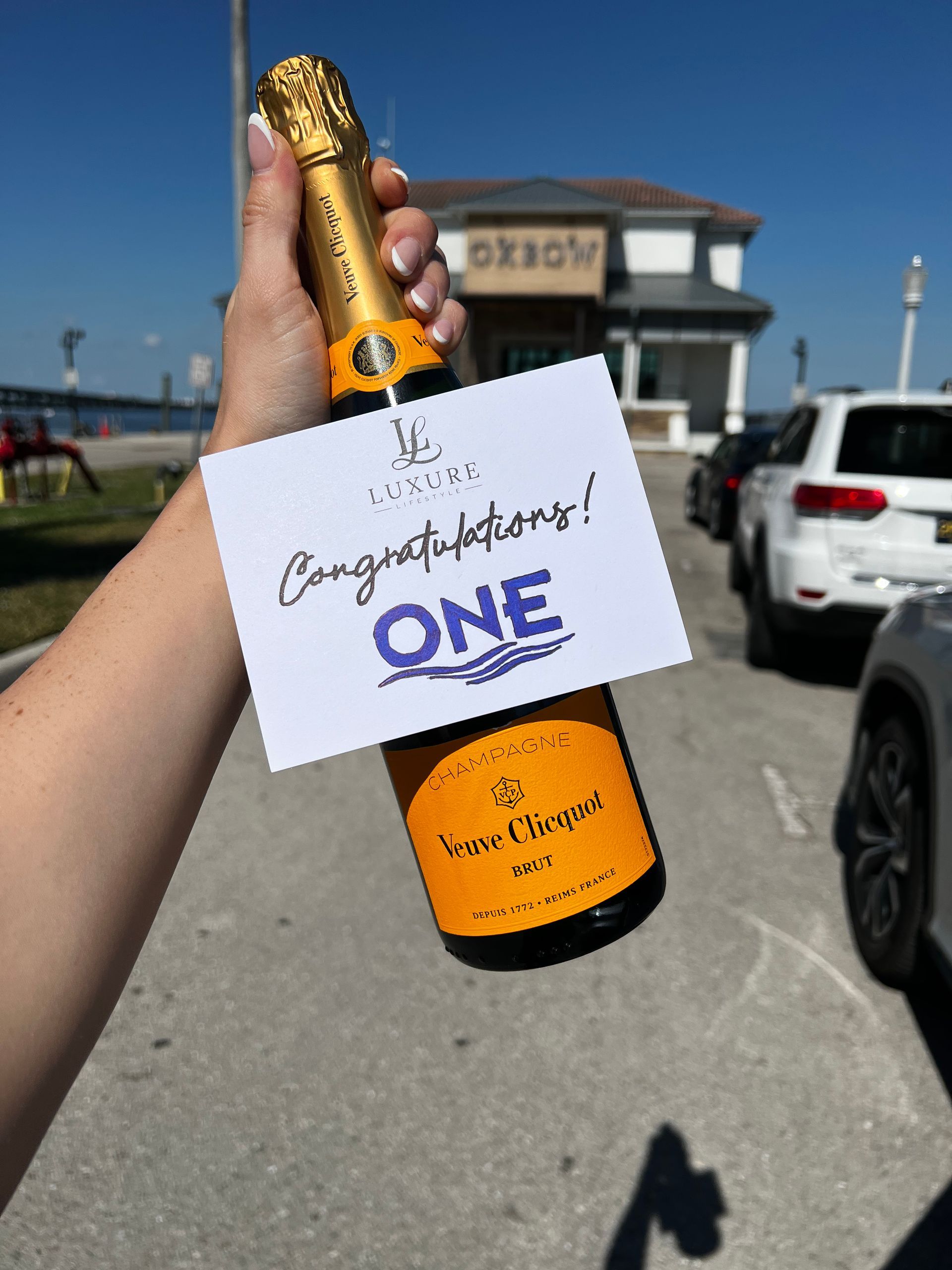 Hand holding Veuve Clicquot champagne bottle with a