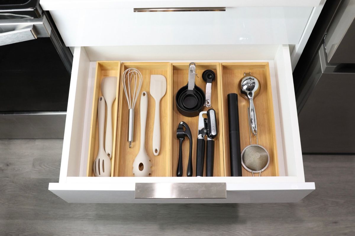 Kitchen drawer with bamboo dividers holding cooking utensils.