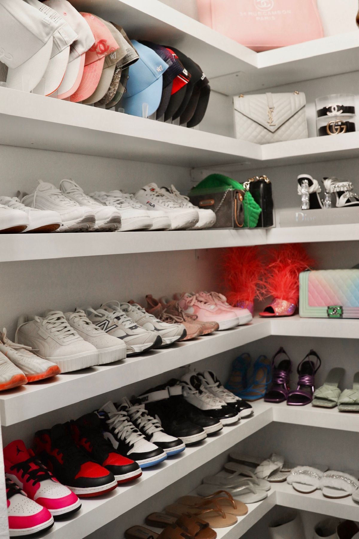 White shelving filled with shoes and bags in a walk-in closet.