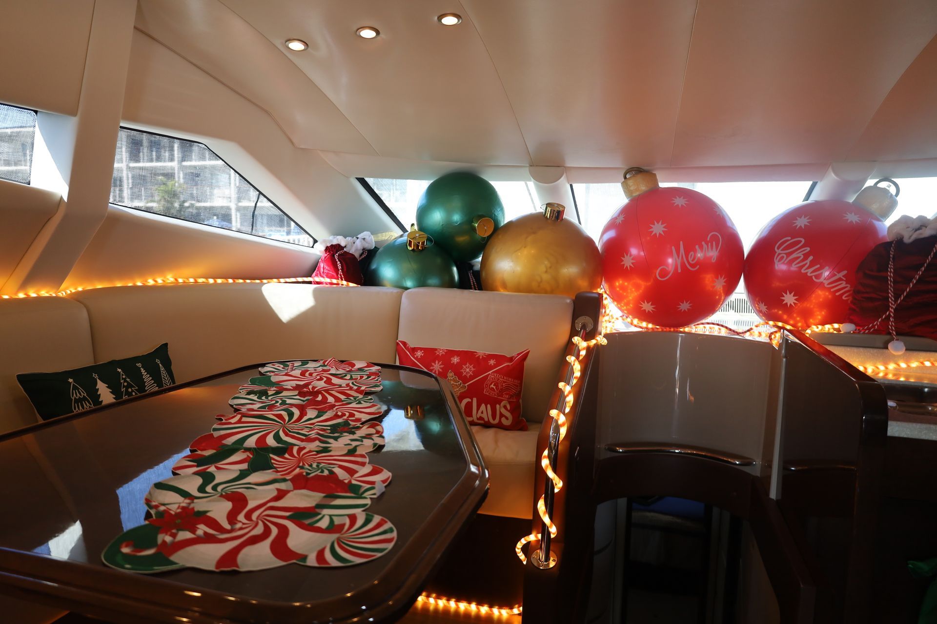 Boat interior decorated for Christmas with large ornaments and garland.
