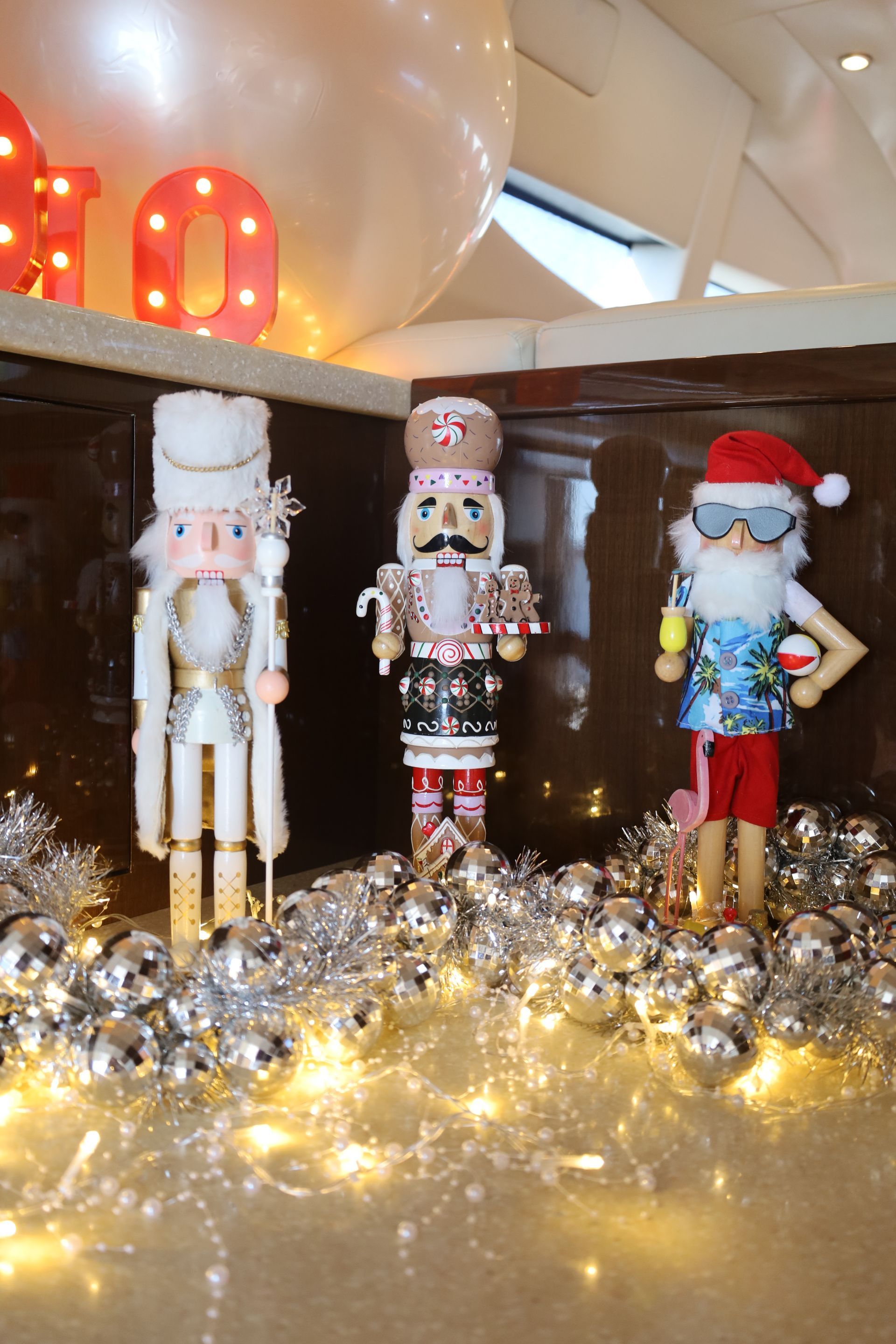 Three Christmas nutcrackers in a display: white, jeweled; gingerbread-themed; and beach Santa with sunglasses.