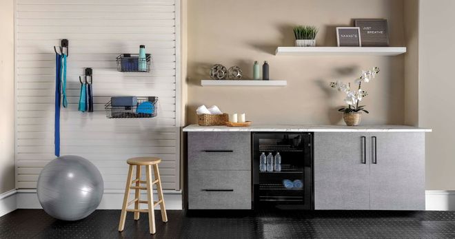 Home gym with exercise ball, storage, and mini-fridge. Neutral colors.