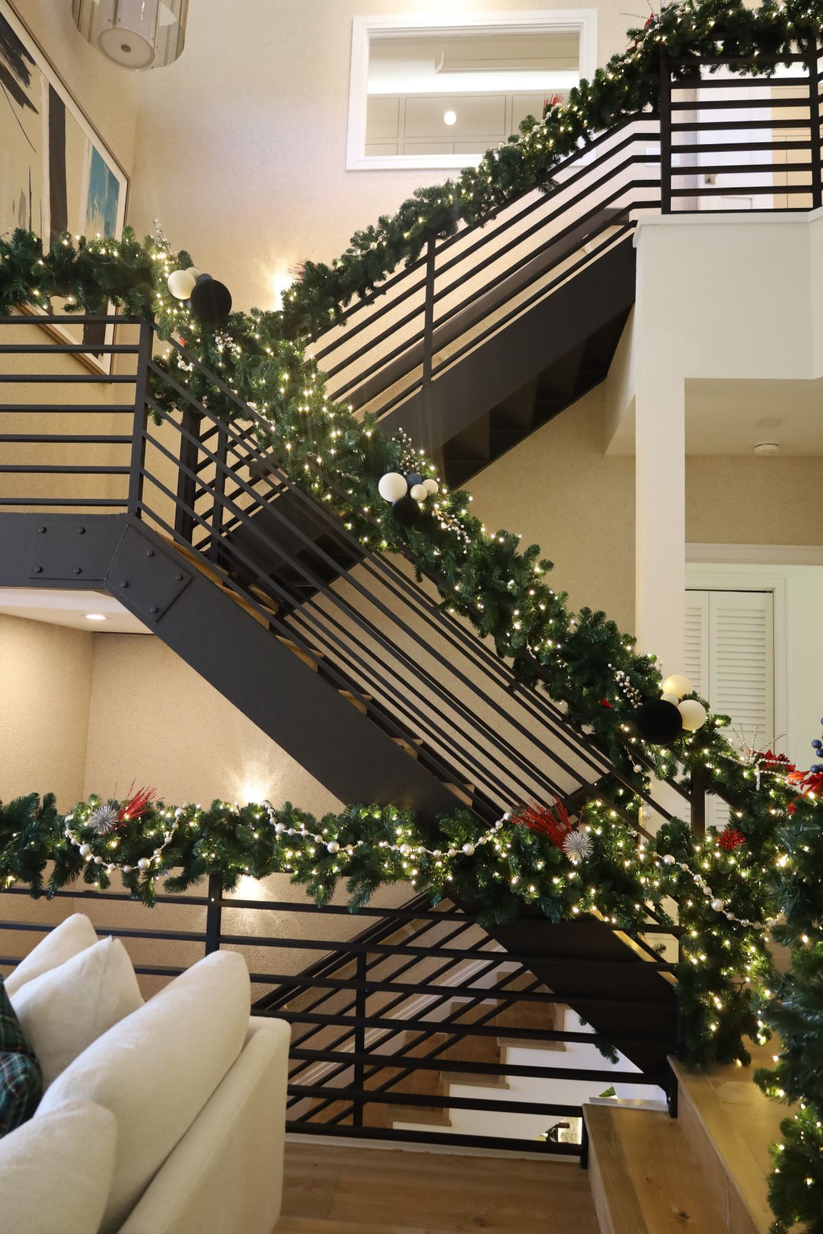 Staircase decorated with evergreen garland and lights for the holidays.