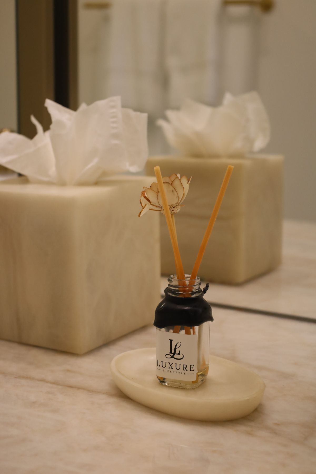 Aromatherapy diffuser and tissue boxes on a marble surface.
