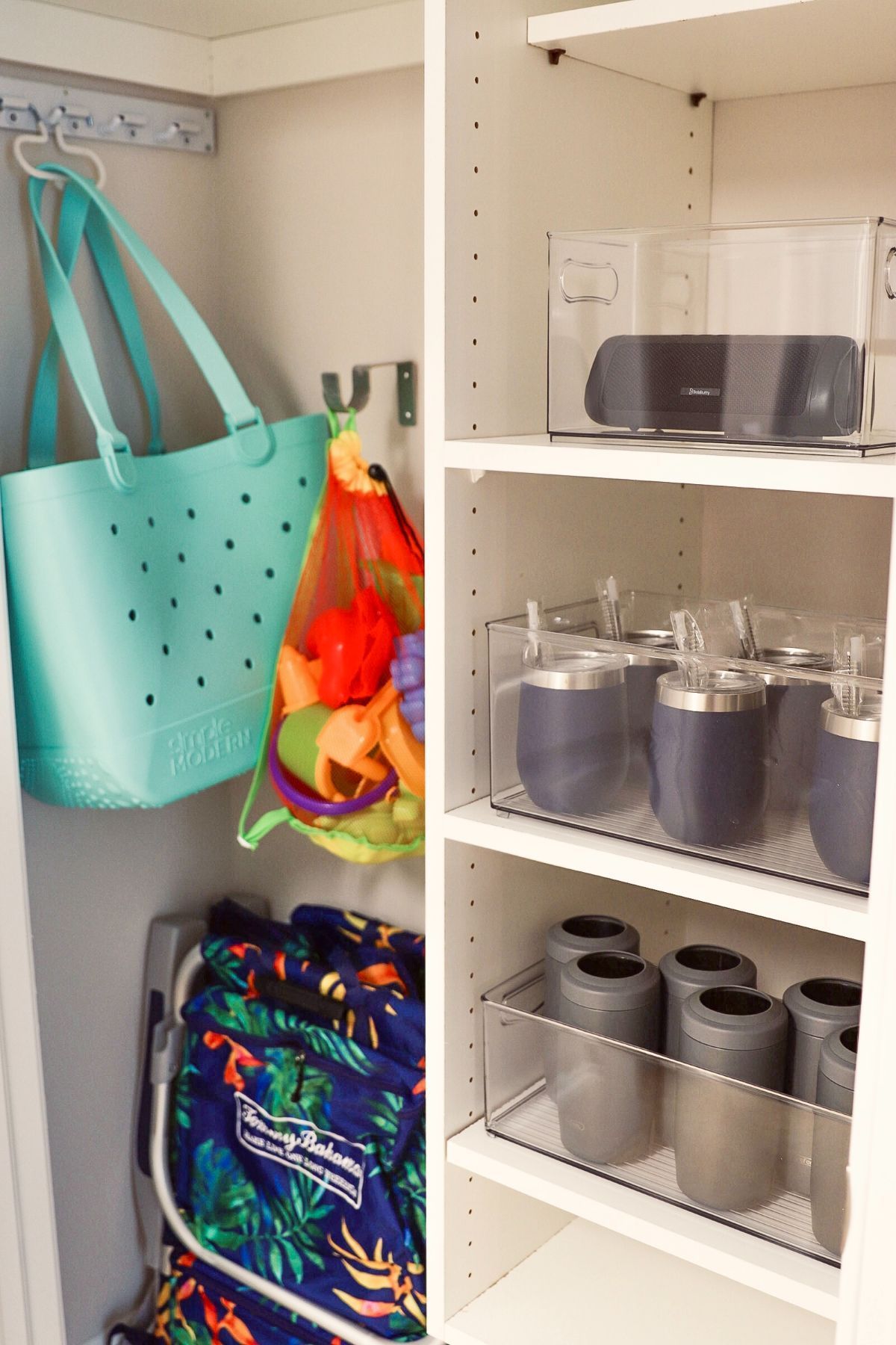 Organized white closet. Left: blue tote, beach towel, folding chair. Right: shelves with drinkware, speaker.