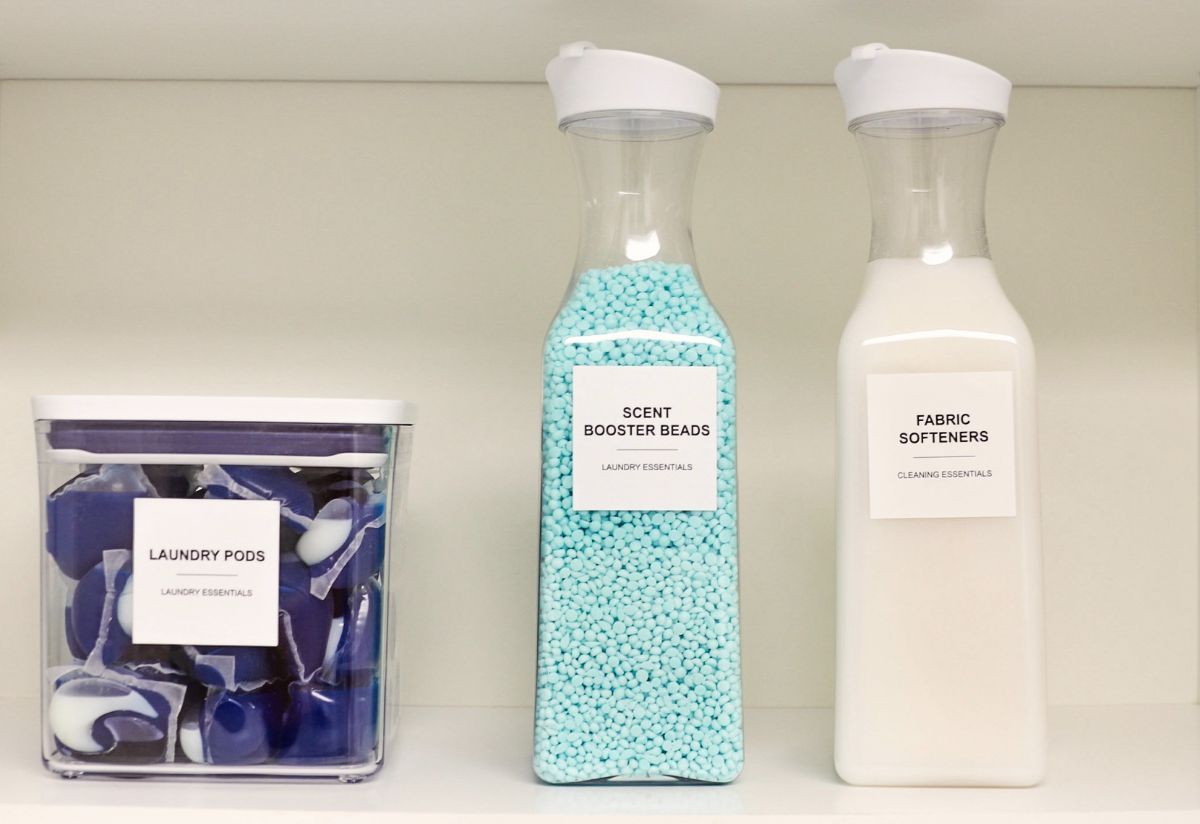Laundry room shelf with laundry supplies: pods, scent beads, and fabric softener in clear containers.