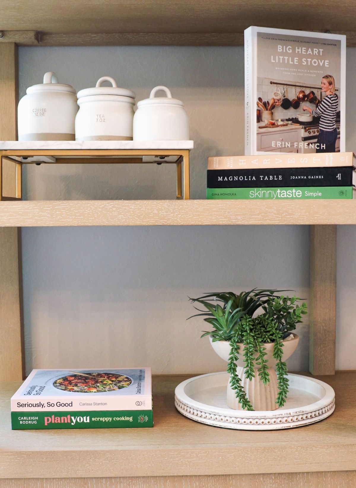 Wooden shelves with cookbooks, jars, and a potted plant.