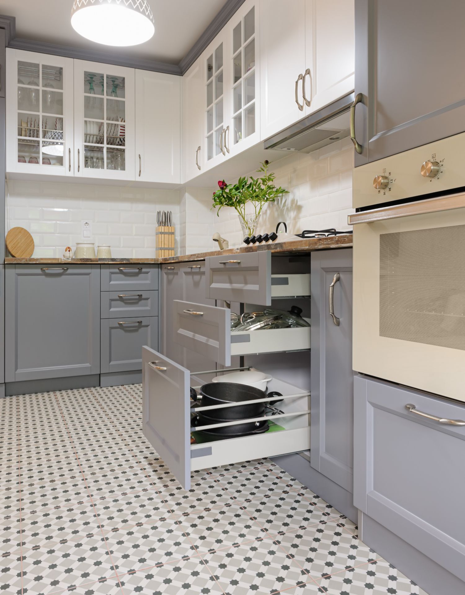 Modern kitchen with stainless steel appliances, open to dining area with chandelier.