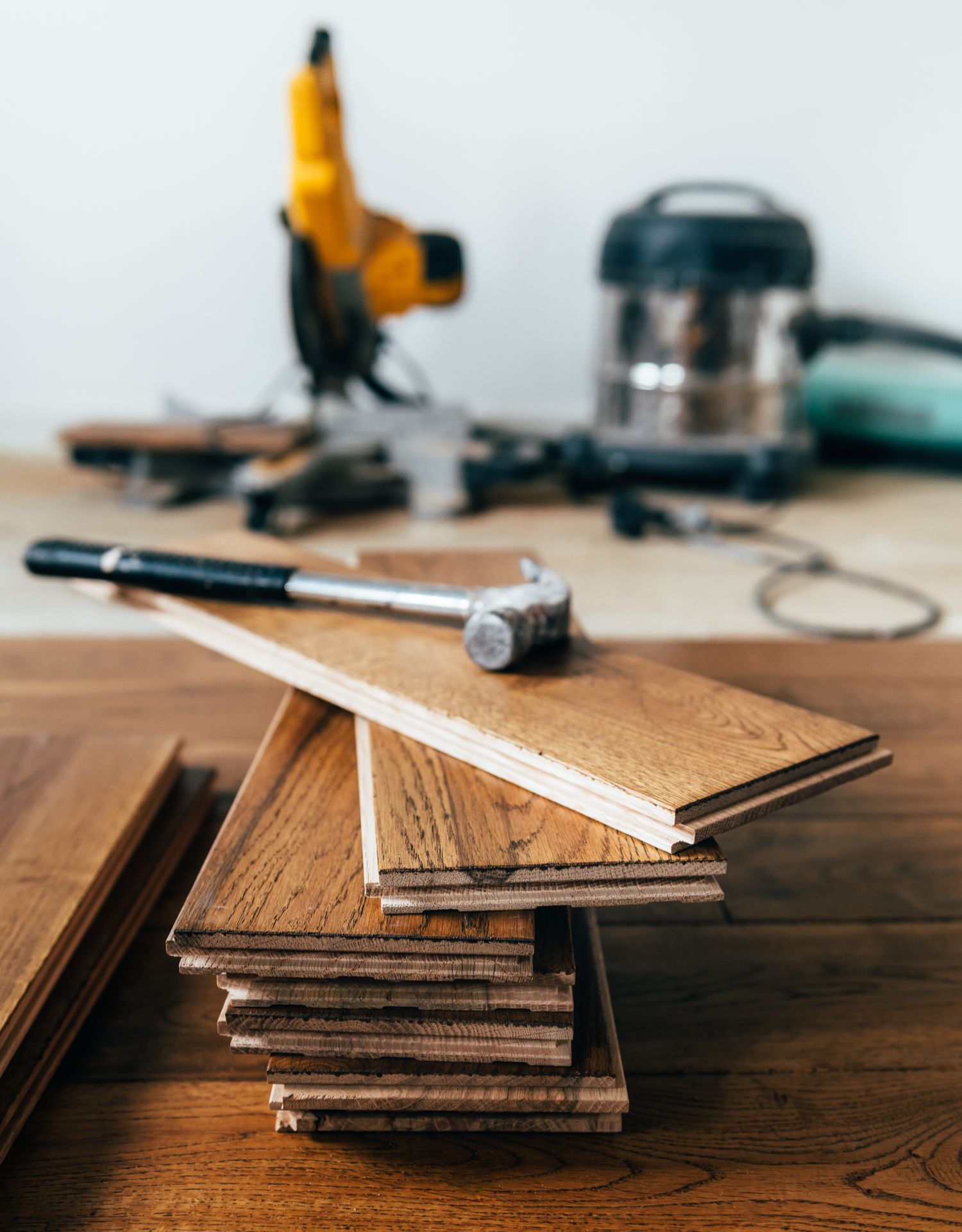 Person installing wood-look tile with a notched trowel and adhesive.