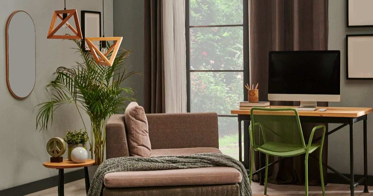 Cozy home office with desk, chair, chaise lounge, mirror, plants, and decorative lighting.