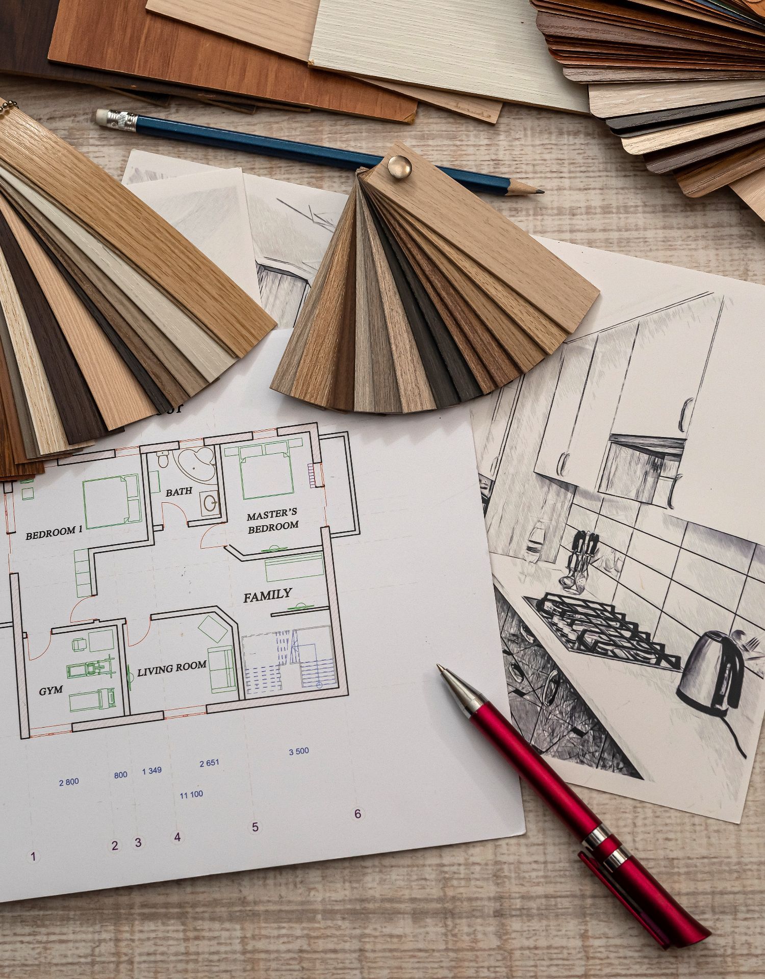 Architectural floor plans and interior design sketches with wood finish samples, a blue pencil, and a red pen.