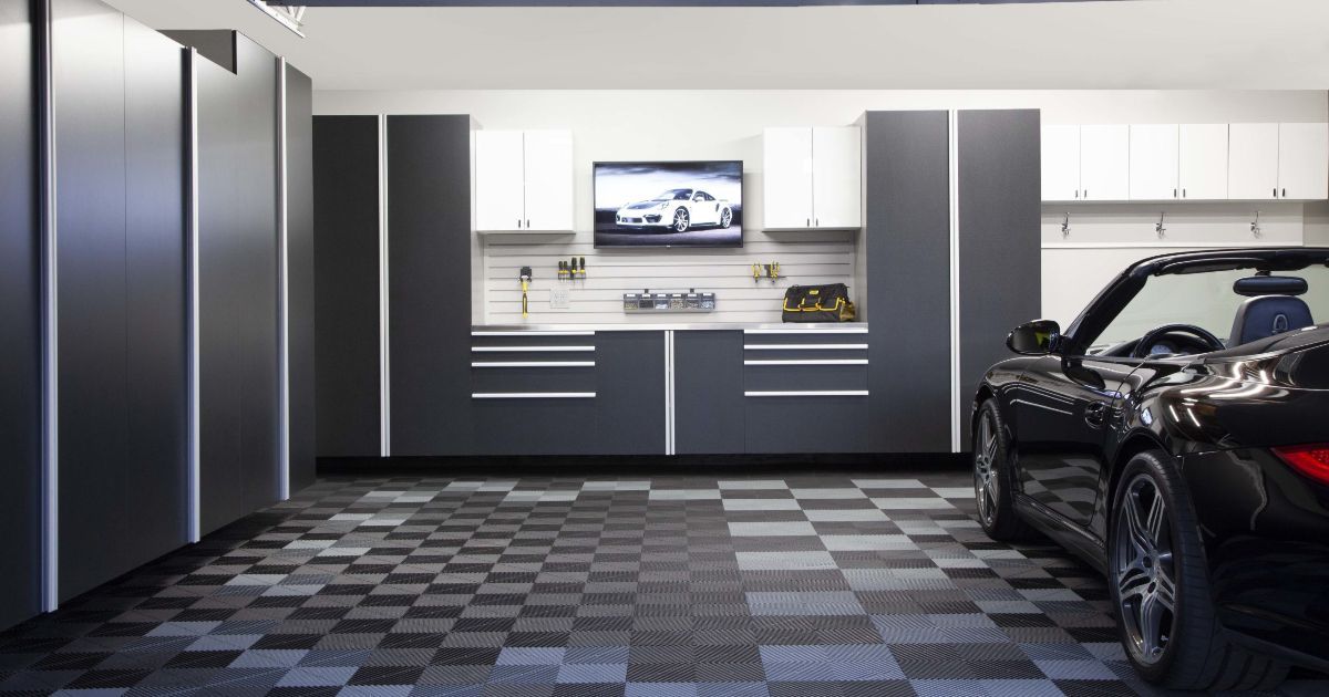 A sleek, organized garage with a black sports car. The floor is checkered, and cabinets are gray and white.