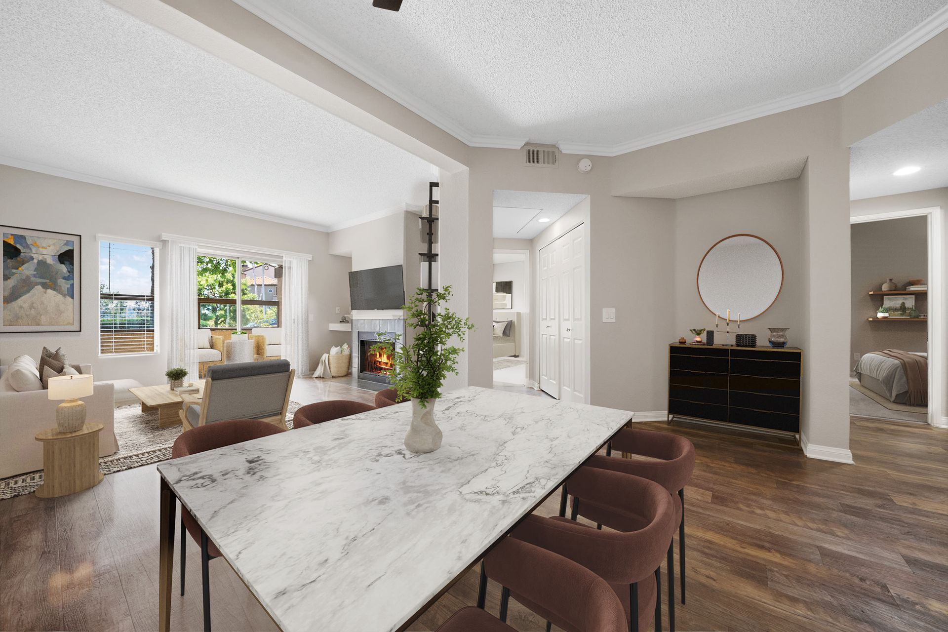 Open-concept dining area with a marble-topped table and living room with a fireplace.