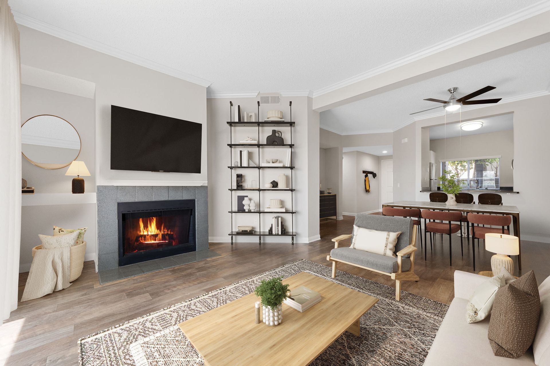 Living room in an apartment with a fireplace, wall-mounted TV, and open dining area.
