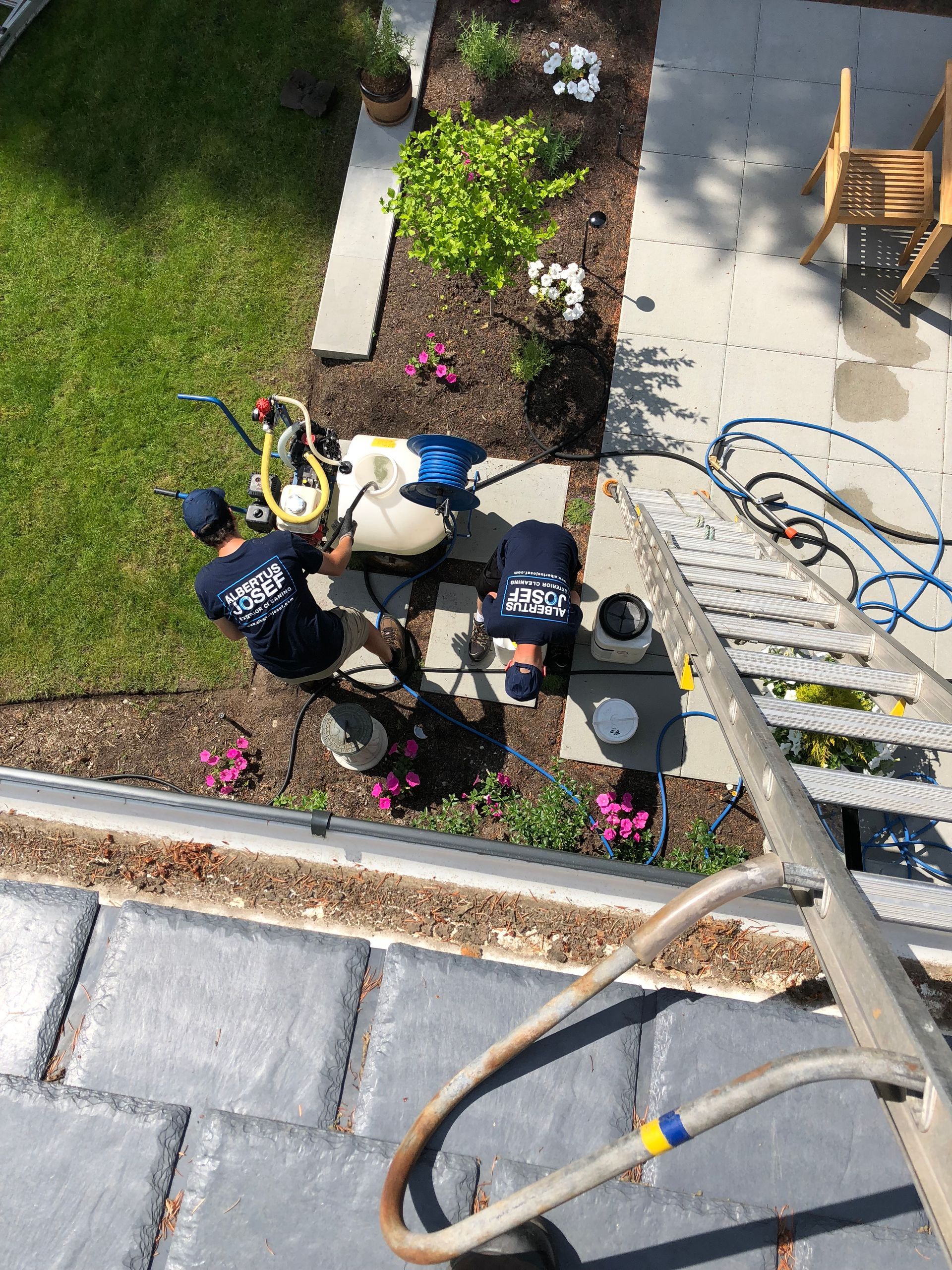 Two men are working on a roof with a ladder.
